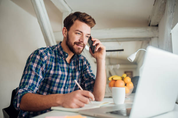 man writing and talking on phone - business business person ceo coffee imagens e fotografias de stock