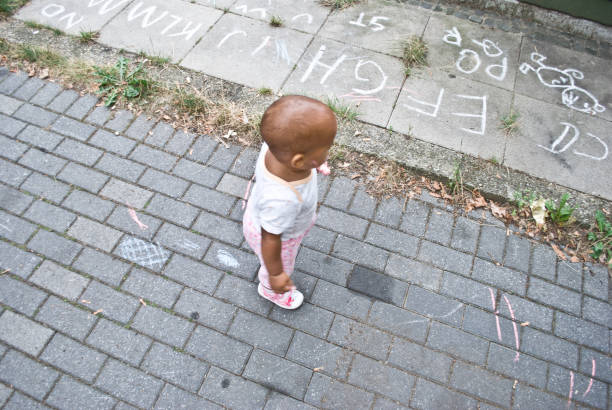 Toddler playing outdoor - drawing on the ground
