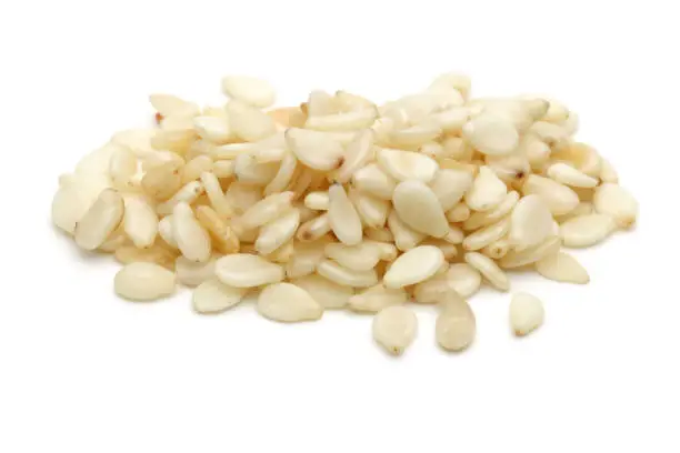 Heap of white sesame seeds isolated on white background