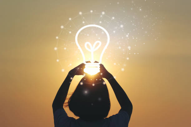 Creative idea and innovation concept, Woman hand holding light bulb on beautiful sunset background