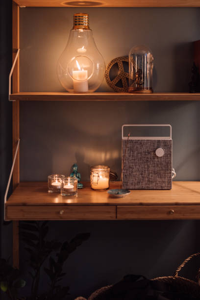 istock Cozy home interior shelf with candles and bluetooth wireless speaker 1125343451
