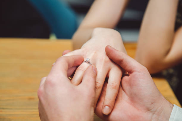 istock Young man puts wedding ring on girls hand. Close up. 1125344393