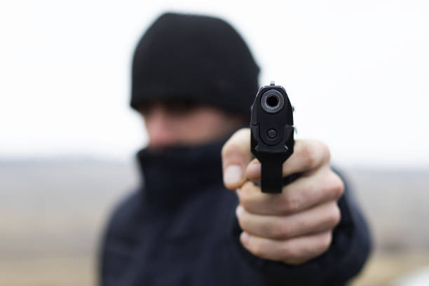 istock Man shooting from a gun, robber commits a crime, criminal concept 1125346562
