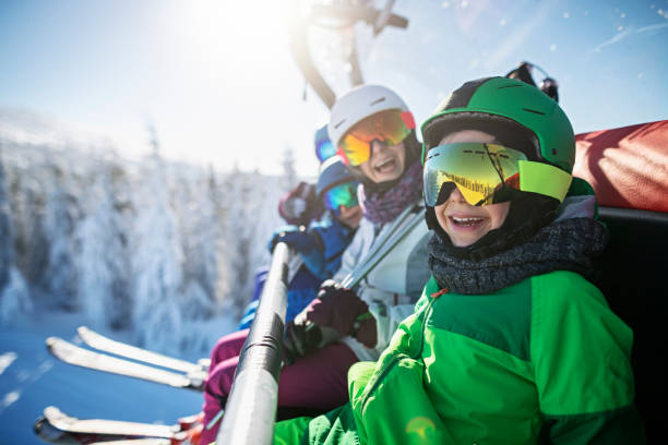 familia disfrutando de esquí en día de invierno soleado - casco de deportes fotos fotografías e imágenes de stock