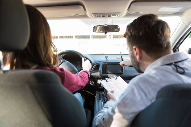 istruttore che guida lo studente a guidare l'auto - driving test foto e immagini stock