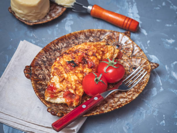 Omelette with vegetables and cheese with whole tomatoes.