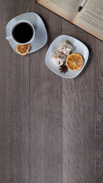 Cup of coffee with book on wooden table
