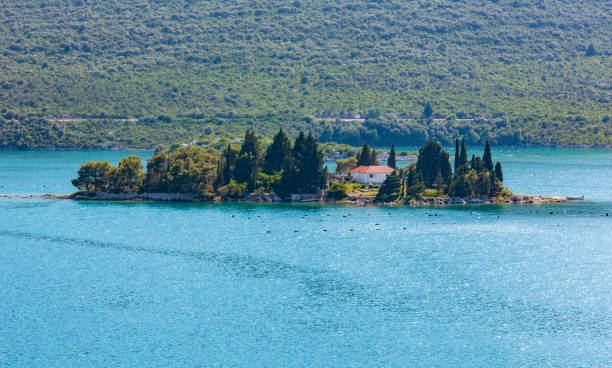 istock Small rocky island with trees and house 1125357571