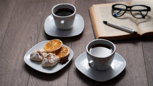 Cup of coffee with book on wooden table