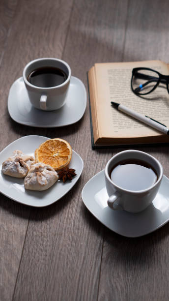 Cup of coffee with book on wooden table