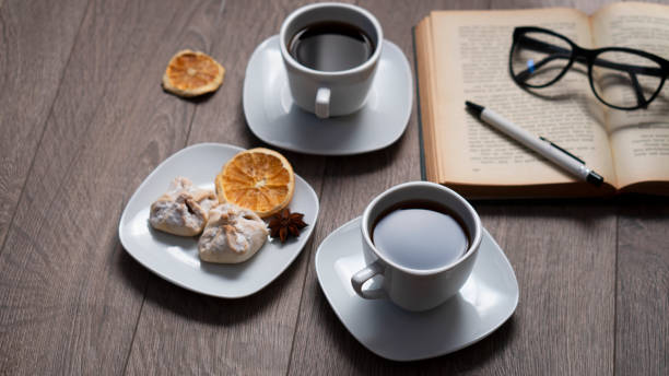 Cup of coffee with book on wooden table