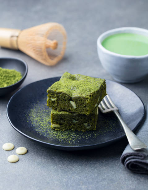 istock Matcha green tea cake, bars, brownie with white chocolate on a plate. Grey stone background. 1125358478
