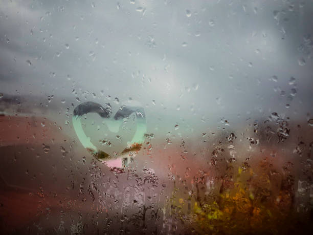 istock drawn heart on the wet window pane with rain drops 1125358655