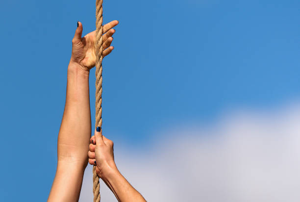 Athletic woman working out and climbing a rope