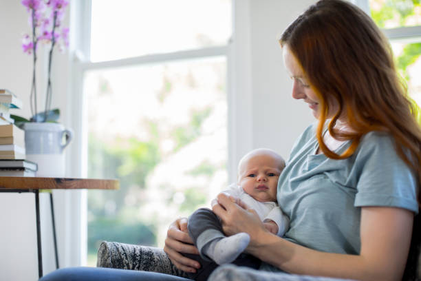 istock Smiling redhead mother sitting with newborn son 1125359117
