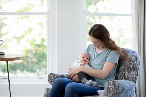 istock Smiling mother sitting with cute newborn son 1125359137