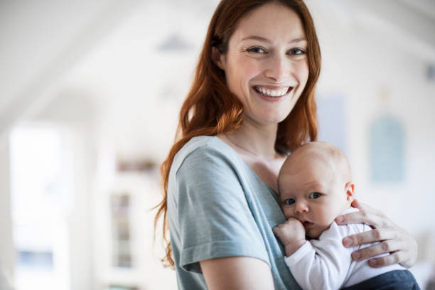 istock Smiling beautiful mother carrying son at home 1125359214