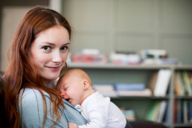 istock Happy redhead mother with sleeping newborn son 1125359335
