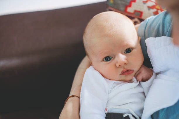 istock Mother carrying newborn son on sofa at home 1125359395
