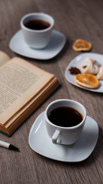 Cup of coffee with book on wooden table