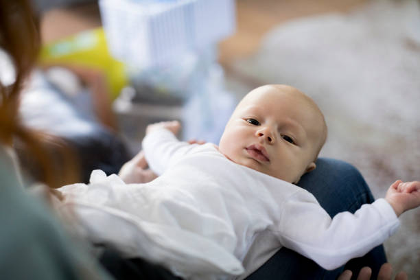 istock High angle view of baby boy lying on woman's lap 1125359593