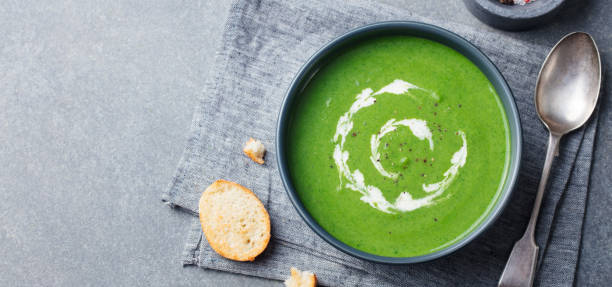 istock Broccoli, spinach cream soup in a bowl with toasted bread. Top view. Copy space. 1125361541