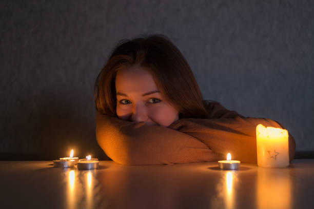 istock beautiful girl by candlelight 1125363443