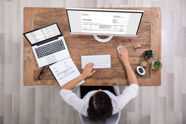 istock Businesswoman Checking Invoice On Computer 1125365637