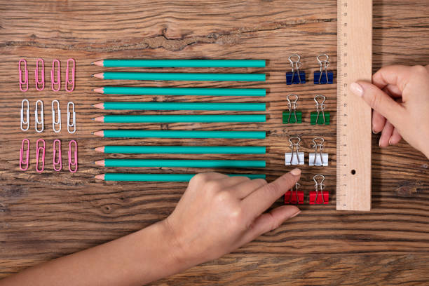 Person Arranging The Clips With Scale Person Arranging The Colorful Bulldog Clips With Scale On Wooden Desk obsessive stock pictures, royalty-free photos & images