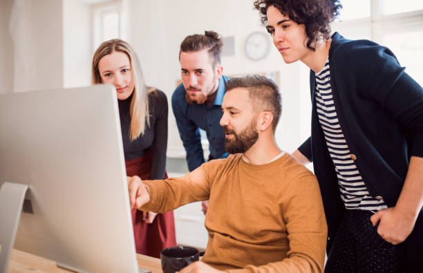 istock Group of young businesspeople looking at laptop screen in office, discussing issues. 1125366121