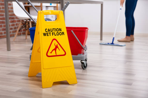 istock Cleaner Standing With Mop And Caution Wet Floor Sign 1125366162