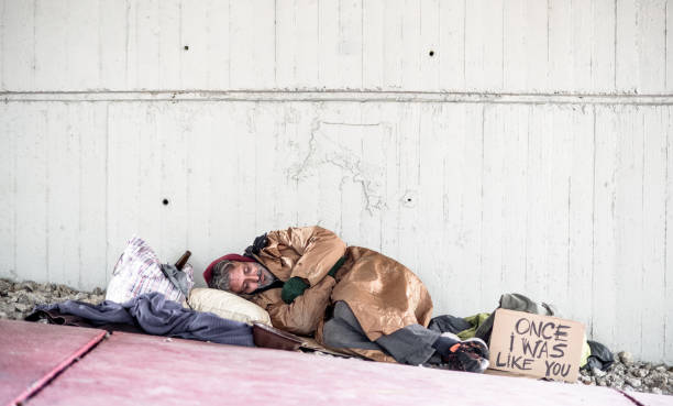 istock Homeless beggar man lying on the ground outdoors in city, sleeping. Copy space. 1125369991