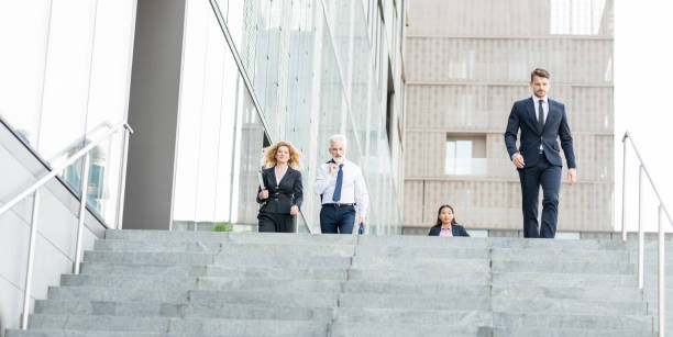 istock Business Couple Walking Down the Stairs 1125370187