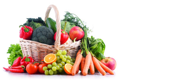 Fresh organic fruits and vegetables in wicker basket Fresh organic fruits and vegetables in wicker basket isolated on white feeding grapes stock pictures, royalty-free photos & images