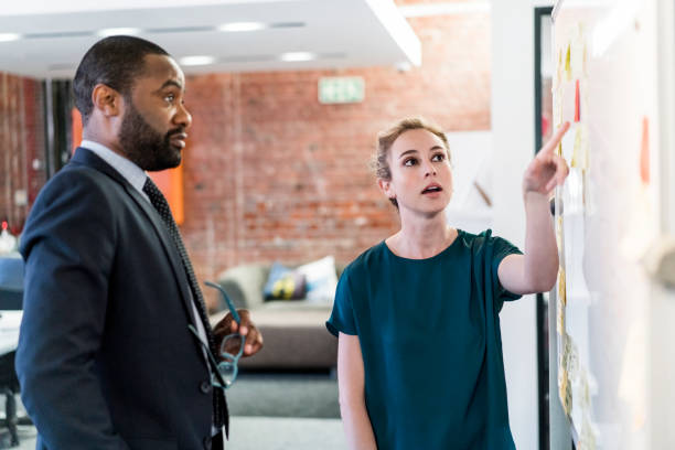 istock Businesswoman pointing at adhesive notes at office 1125371591