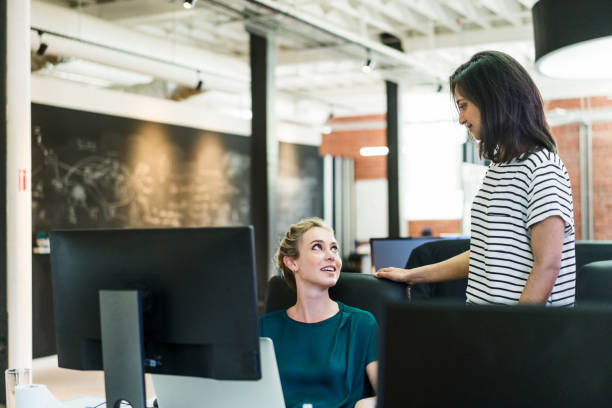 istock Smiling businesswomen talking at creative office 1125372259