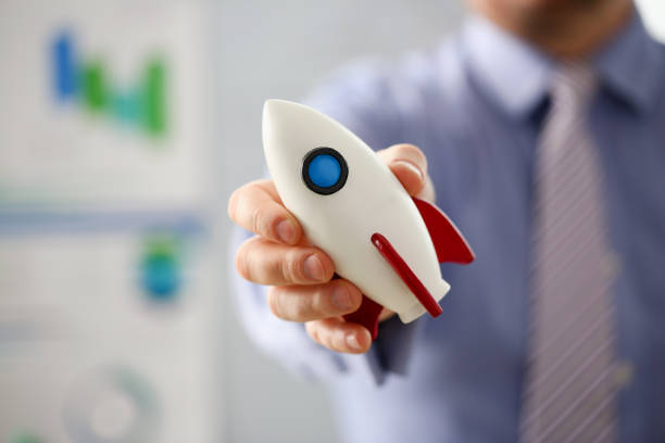 istock Businessman in suit hold white rockrt in hand 1125376804