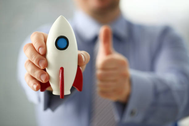 istock Businessman in suit hold white rockrt in hand 1125376805