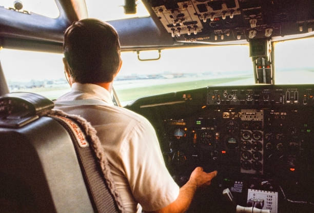 Seattle, Washington, USA – September 7, 1983 – Over the shoulder view of a pilot at the cockpit of a 737-300 aircraft preparing for take off.