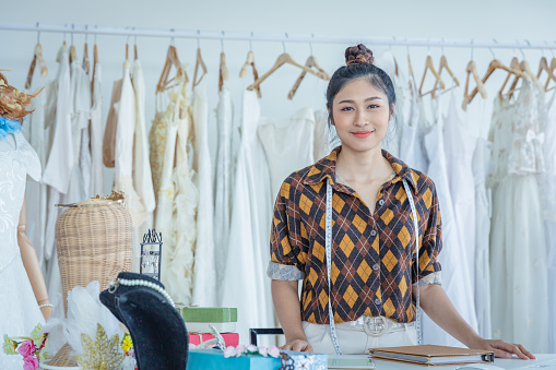 Young Asian woman working at clothes designer, with happiness.