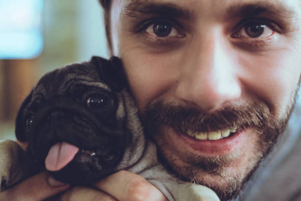 istock Young Man And Puppy Pug 1125383094