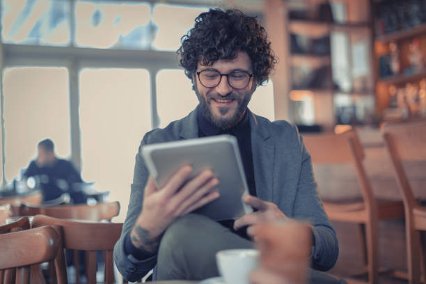 istock Man sitting in the coffee shop and using tablet 1125383354