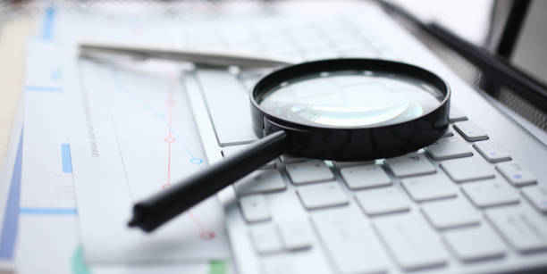 istock Magnifying glass lies on white keyboard on 1125384972