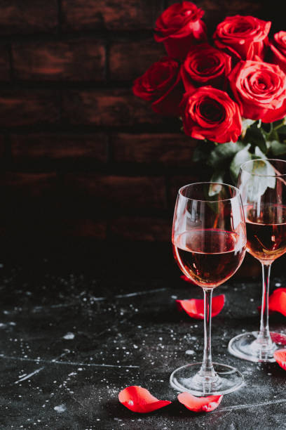 zwei gläser wein rose wein für ehe valentinstag liebe geburtstagsfeier auf dunklem hintergrund - cluster verlobungsringe stock-fotos und bilder