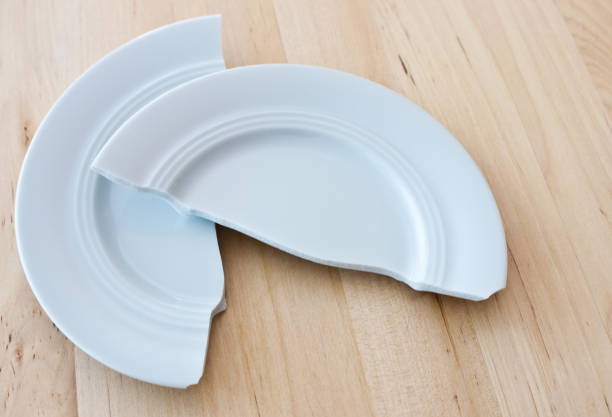 istock Broken plate against wooden background 1125392745