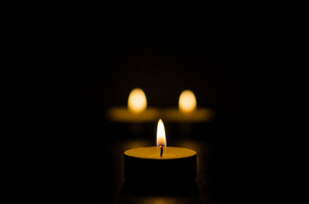 istock Three burning candles isolated on black background. 1125394714