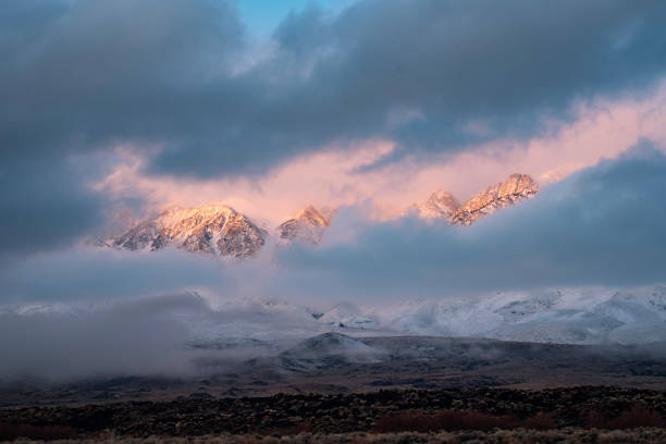 istock snowy mountain peaks cloudbreak view through dark snow clouds 1125395040
