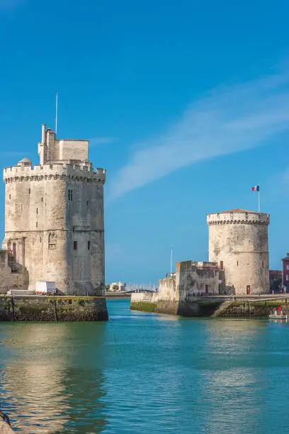 Two towers of old dock fortress in La Rochelle on sunny day, vertical picture