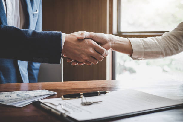 istock Real estate agent and customers shaking hands together celebrating finished contract after about home insurance and investment loan, handshake and successful deal 1125399429