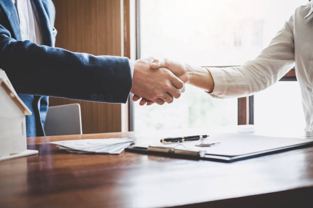 istock Real estate agent and customers shaking hands together celebrating finished contract after about home insurance and investment loan, handshake and successful deal 1125399514